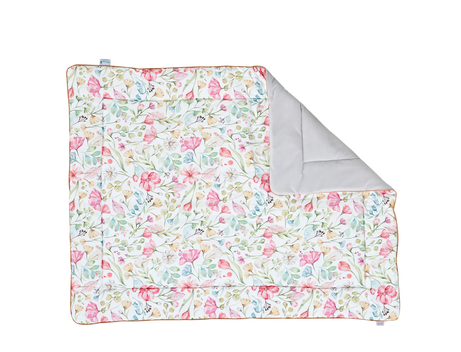 Packshot kołdry pikowanej z kolekcji Floral marki Pinio, wielokolorowa z motywem kwiatowym (różowe kwiaty, zielone i niebieskie liście na białym tle), częściowo odwrócona pokazująca szary spód, rozmiar nieokreślony