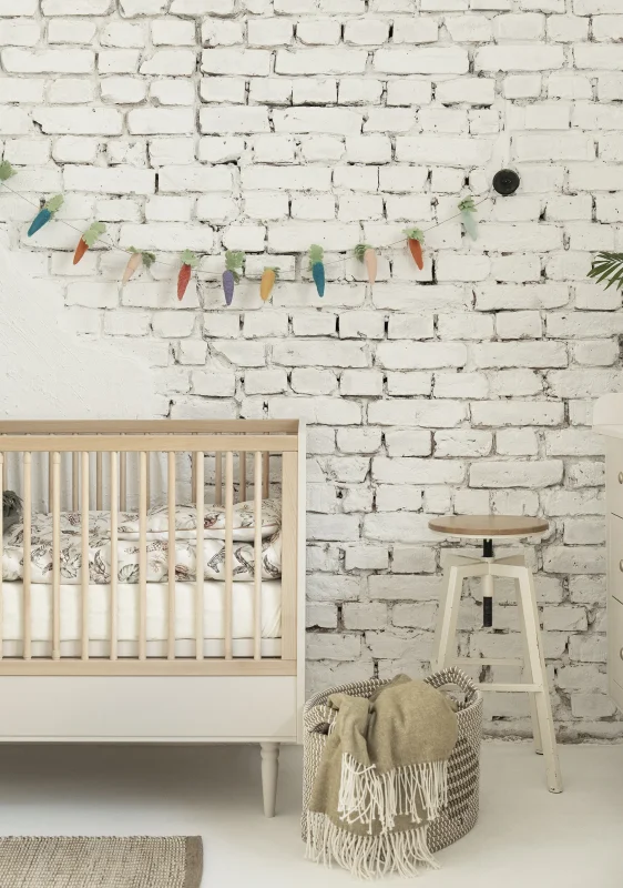 Łóżeczko niemowlęce z kolekcji Petite w kolorze szampańskim, jasne drewniane wykończenie z białymi panelami, standardowy rozmiar, zdjęcie lifestyle w urządzonym wnętrzu