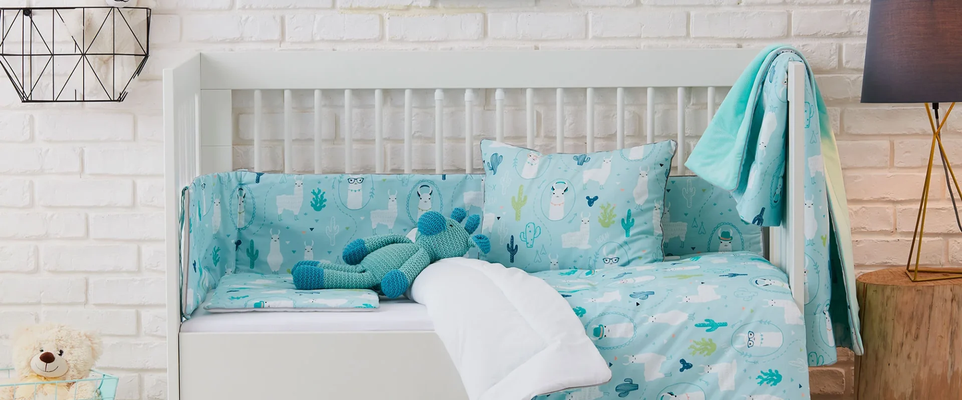 Białe łóżko dziecięce z szufladą z kolekcji Pinio, z niebieską pościelą w motywy lam (llamas), aranżacja lifestyle (nie packshot)