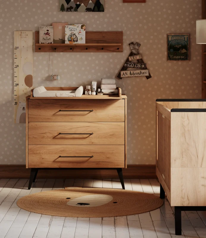Komoda z przewijakiem z kolekcji Retro w kolorze jasnego drewna, trzy szuflady z czarnymi uchwytami i czarnymi nóżkami, standardowy rozmiar, zdjęcie lifestyle w aranżacji wnętrza