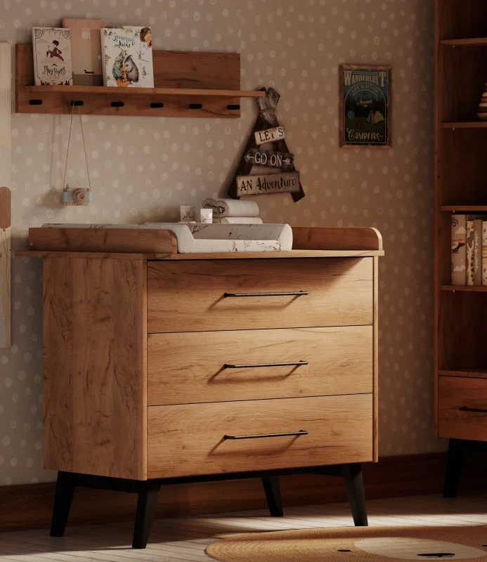 Komoda z przewijakiem z kolekcji Retro Baby, jasne drewno z widocznym usłojeniem, trzy szuflady, czarne nóżki i uchwyty, standardowy rozmiar, zdjęcie lifestyle w urządzonym wnętrzu