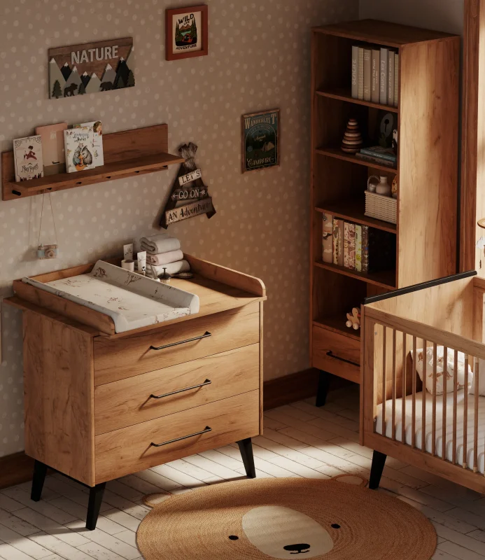 Zdjęcie lifestyle (aranżacja wnętrza, nie packshot) z kolekcji Retro Baby przedstawiające drewnianą komodę do przewijania niemowląt z trzema szufladami i nakładanym przewijakiem w kolorze jasnego naturalnego drewna, stojącą obok drewnianego łóżeczka dziecięcego oraz wysokiego regału w urządzonym pokoju niemowlęcym