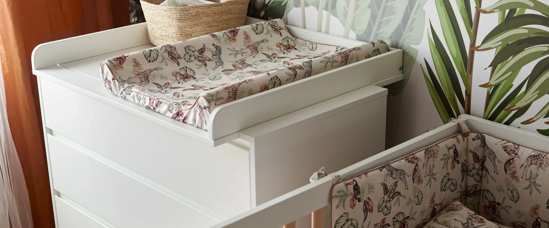 Lifestyle zdjęcie mebli z kolekcji Swing White przedstawiające białe łóżeczko niemowlęce z drewnianymi szczebelkami oraz białą komodę z przewijakiem, kolor biały, standardowy rozmiar dla niemowląt