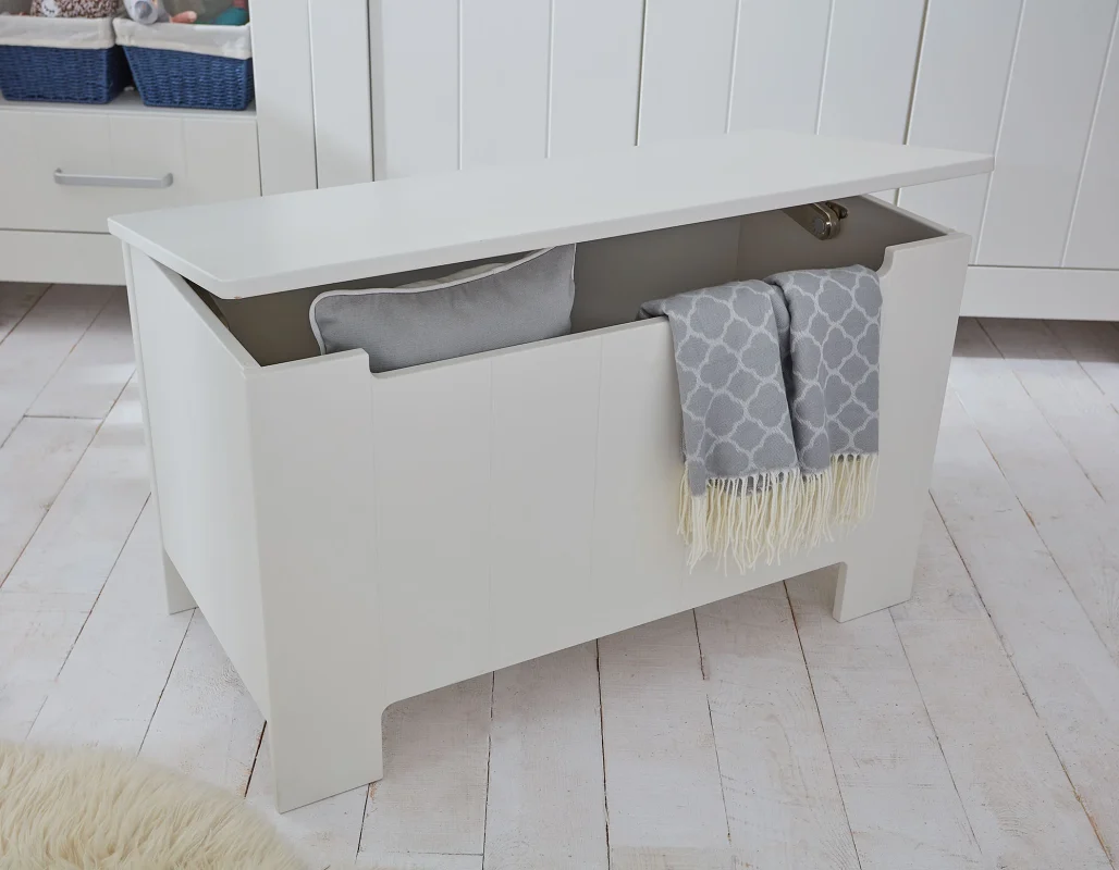 Biała skrzynia na zabawki z pojemnikiem i otwieranym wiekiem z kolekcji Calmo, kolor biały, rozmiar średni, to zdjęcie lifestyle (nie packshot) z aranżacją w jasnym wnętrzu